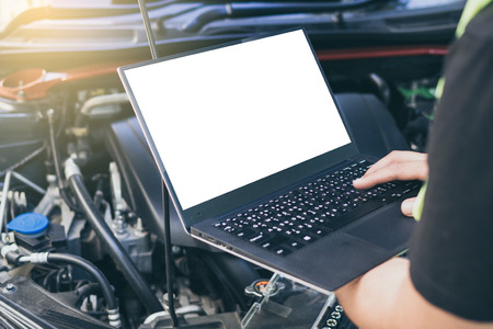 Close up engineer  mechanic using electrnoic diagnostic equipment to tune a car, Laptop blank screen.の写真素材