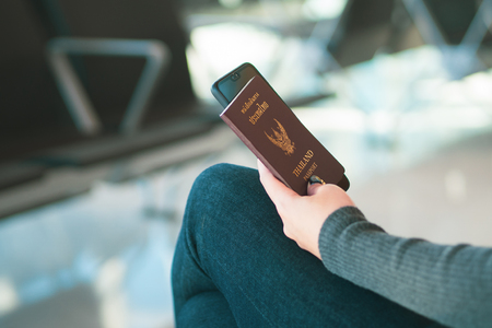 Travel concept. Closeup of woman hand holding Thai passport ready to boarding.の写真素材