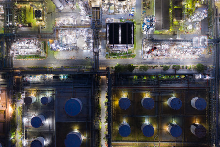 Aerial view oil and gas industrial, Refinery factory oil storage tank and pipeline steel at night