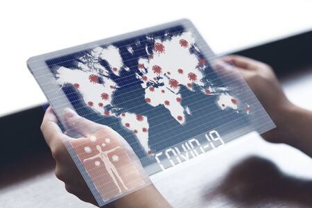 Woman holding tablet watching world map with Coronavirus or Covid-19 outbreak around the world