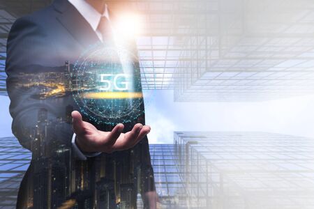 5G technology and global communication concept, Businessman holding world of 5G hologram on hand with technology icon, network, connection, internet in modern cityの写真素材