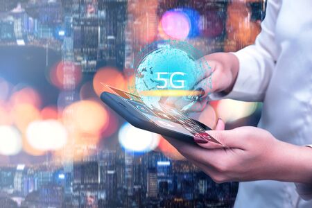 5G technology and global communication concept, Woman  using smart phone with world hologram, network, connection, internet in modern cityの写真素材