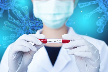 Doctor holding blood sample tube of corona virus infected on abstract virus blue backgroundの写真素材