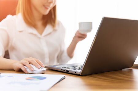 Young woman sale person analzing sale report on desk working at homeの写真素材