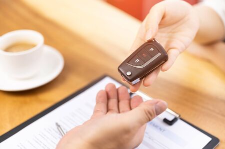 Car loan, contract agreement,buying and rent car concept, Sales Person holding car key on handの写真素材