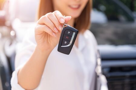 Car loan, contract agreement,buying and rent car concept, Saleperson holding car key on handの写真素材