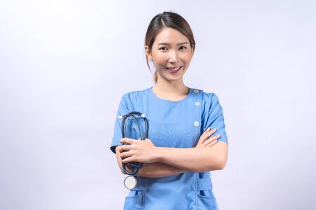 Portrait of smiling Asian nurse isolated on white backgroundの写真素材