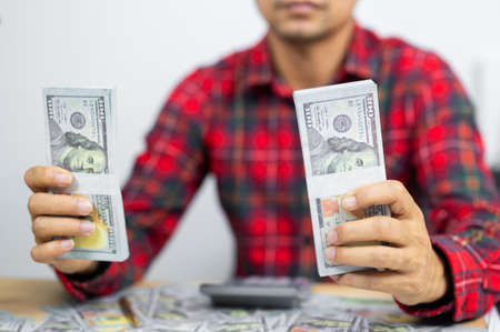 Man counting dollar banknotes on desk. concept of salary,tax and income