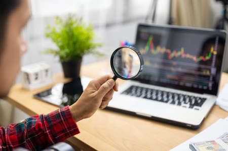 Man analyzing stock exchange or forex graph on laptop at home concept of investment and freelancerの写真素材