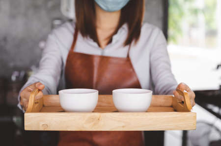 New normal startup small business Portrait of Asian woman barista wearing face mask working in...