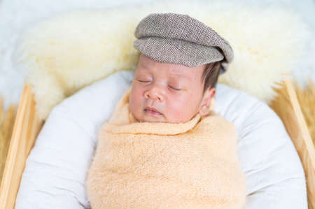 Newborn baby in costume sleeping in baby case
