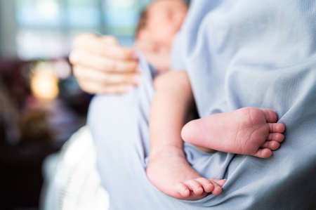 Muslim woman holding newborn baby in her armの写真素材