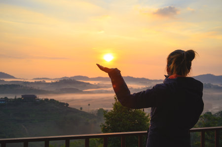 Asian woman enjoys the view of misty landscape in morning at Khao Kho hill in Phetchabun, Thailandの写真素材