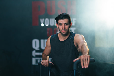 Caucasian white man gym trainer sitting on stationary bicycle on cardio machine in fitness gym. Health care and fitness in gym conceptの写真素材