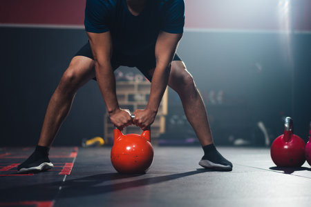 Man lifting kettlebell training for maintain muscle in fitness club or gym.の写真素材