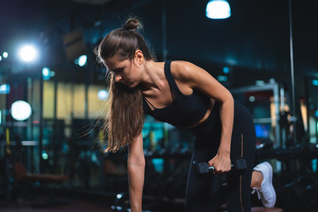Caucasian young woman in sportswear lifting dumbbell  in fitness club or gym.の写真素材