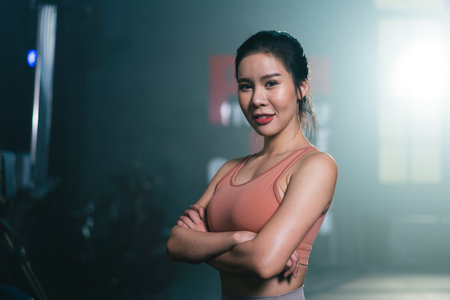 Portrait of Asian female athlete wearing sportswear looking at camera in fitness gymの写真素材