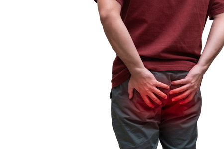 Close up of a man suffering from anal pain. Painful spot highlighted in red.