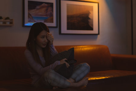 Asian woman watching horror movie scared at nightの写真素材