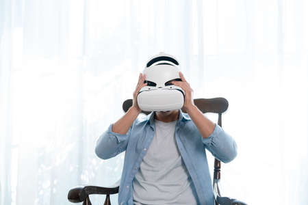 Man wearing virtual reality glasses while sitting at home.の写真素材