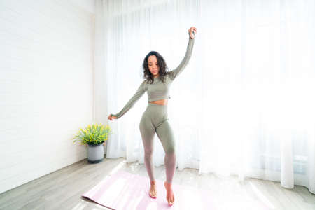Athletic woman in sportswear doing yoga at homeの写真素材