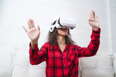 Woman wearing virtual reality goggles at home. The concept of virtual reality.の写真素材