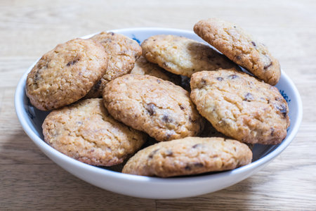 A white bowl full of home made chocolate chip cookiesの写真素材