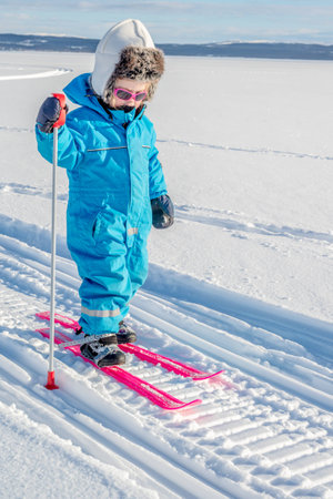 Young girl cross-country skiing. In snowmobile tracks.の写真素材