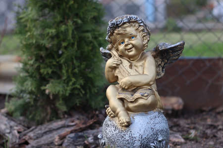 Clay figurine of a gilded Cupid seated on a ball