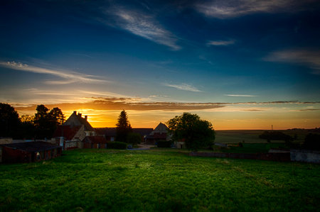 The sun peaks over the top of a French farmhouseの写真素材