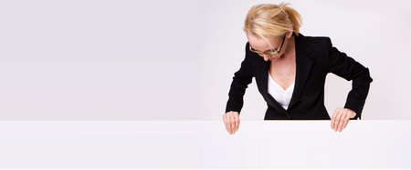 Businesswoman holding blank sign isolated on whiteの写真素材