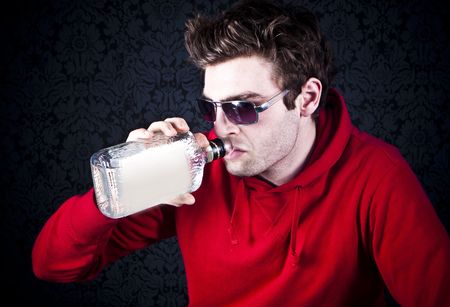 young man drinking and feeling despairの写真素材