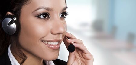  Isolated portrait of a beautiful helpdesk or support line operator answering a call.  の写真素材