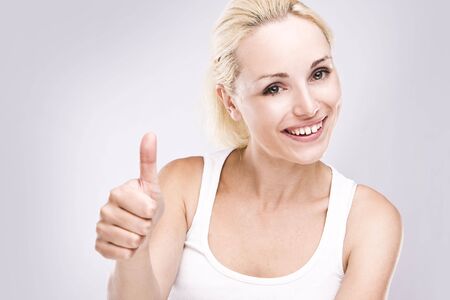 Portrait of an attractive young female with thumbs up.の写真素材