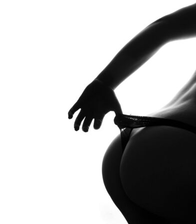 beautiful feminine bottom  with the hand holding knickers against white backgroundの写真素材