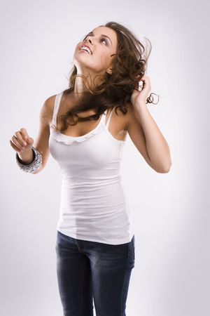 isolated nice woman on jeans and white tanktop dancing の写真素材