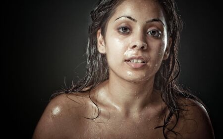 Portrait of beautiful young woman with water all over the face and hair の写真素材