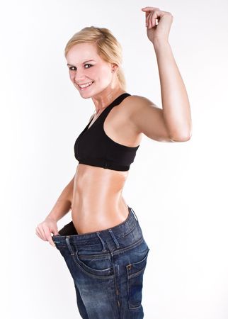 emale wearing old jeans who has lost weight showing success on her faceの写真素材