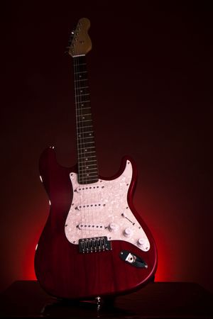 electric red guitar on dark backgroundの写真素材