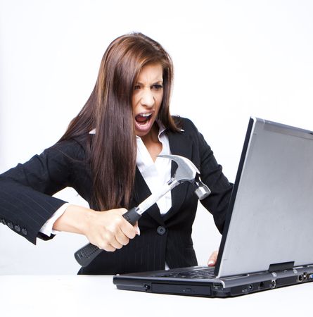 angry business woman about to demolish her laptop with a hammerの写真素材