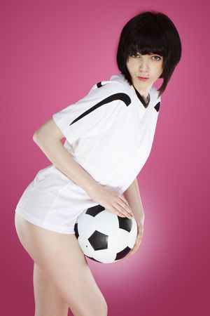 cute sexy player posing with ball on pink backgroundの写真素材