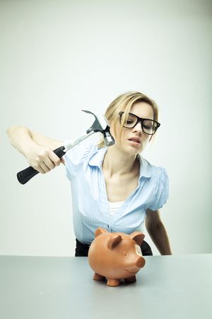 Young woman breaking a piggy bankの写真素材
