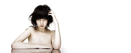 portrait of young nude brunette woman with tattooの写真素材