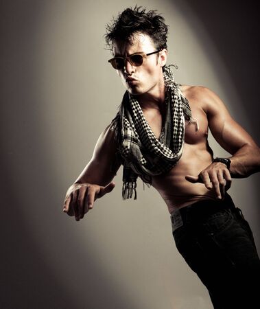 young male posing on the grey studio backgroundの写真素材