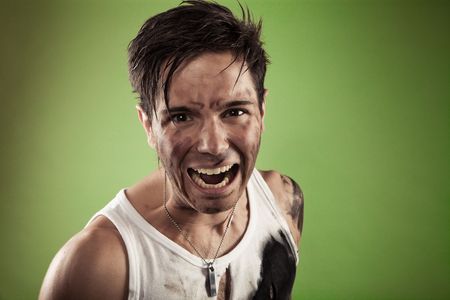 screaming dirty man photo on green backgroundの写真素材