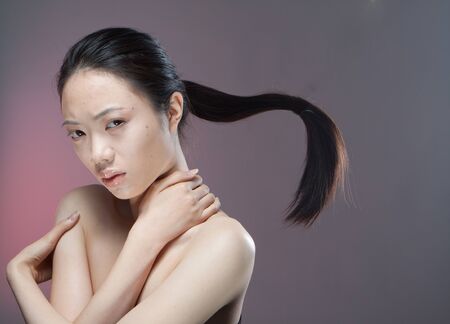 A serious young teenage girl with hair in a flying ponytail.の写真素材