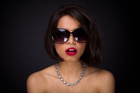 sexy brunette elegant woman expressed wearing neckles  and sunglasses