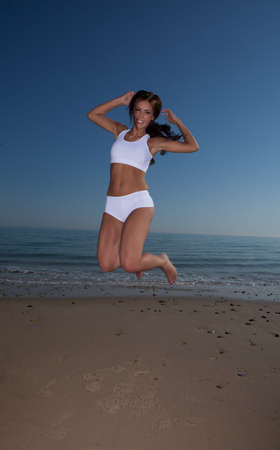 fitness brunette woman exercise on the beach の写真素材