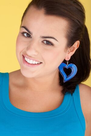 Sexy Woman With Heart Earring beautiful smiling woman wearing turquoise with large matching turquoise heart earring.の写真素材