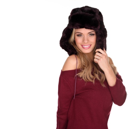 Pretty smiling blonde in furry winter hat and off the shoulder dress isolated on whiteの写真素材